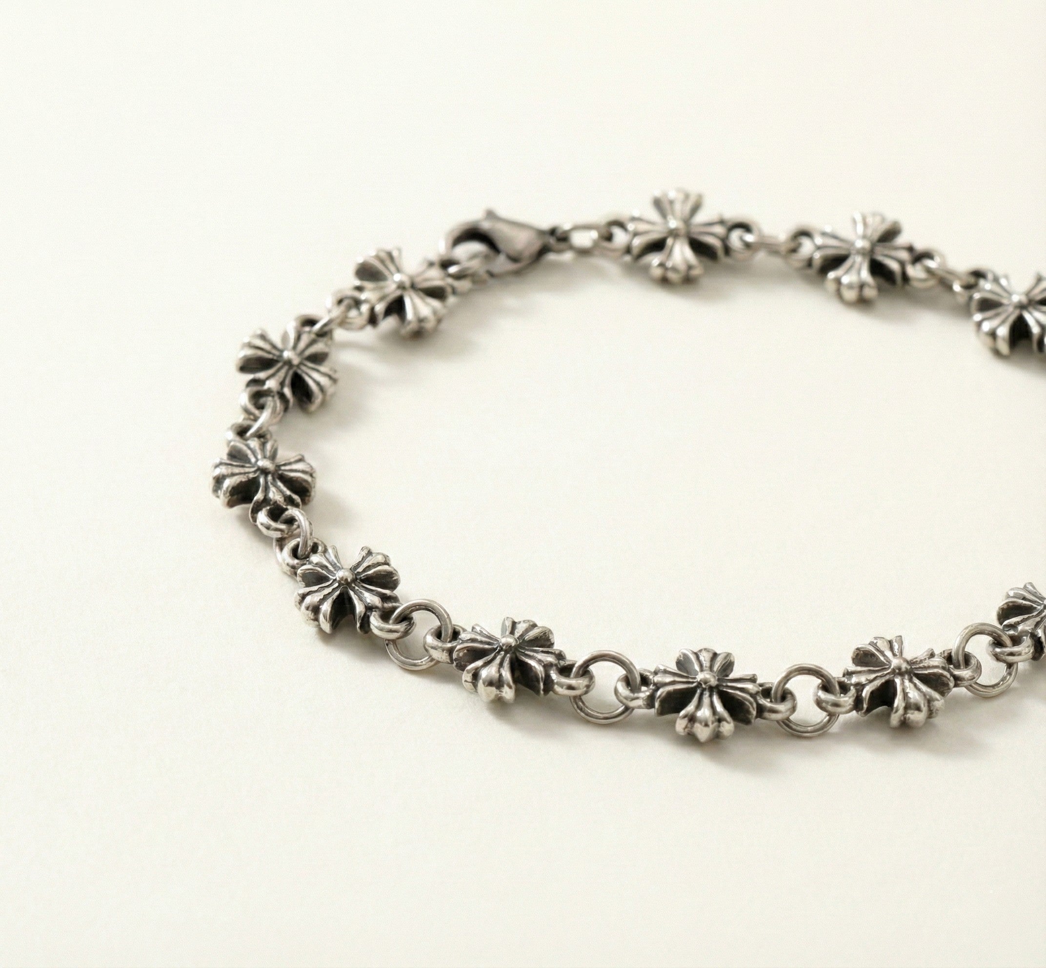 Silver bracelet with floral designs on a white background
